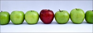 red apple between green apples